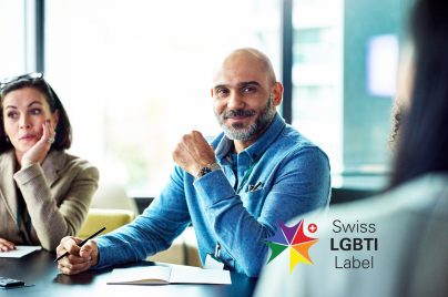 Ein Mann, der während einer Besprechung lächelnd am Tisch sitzt