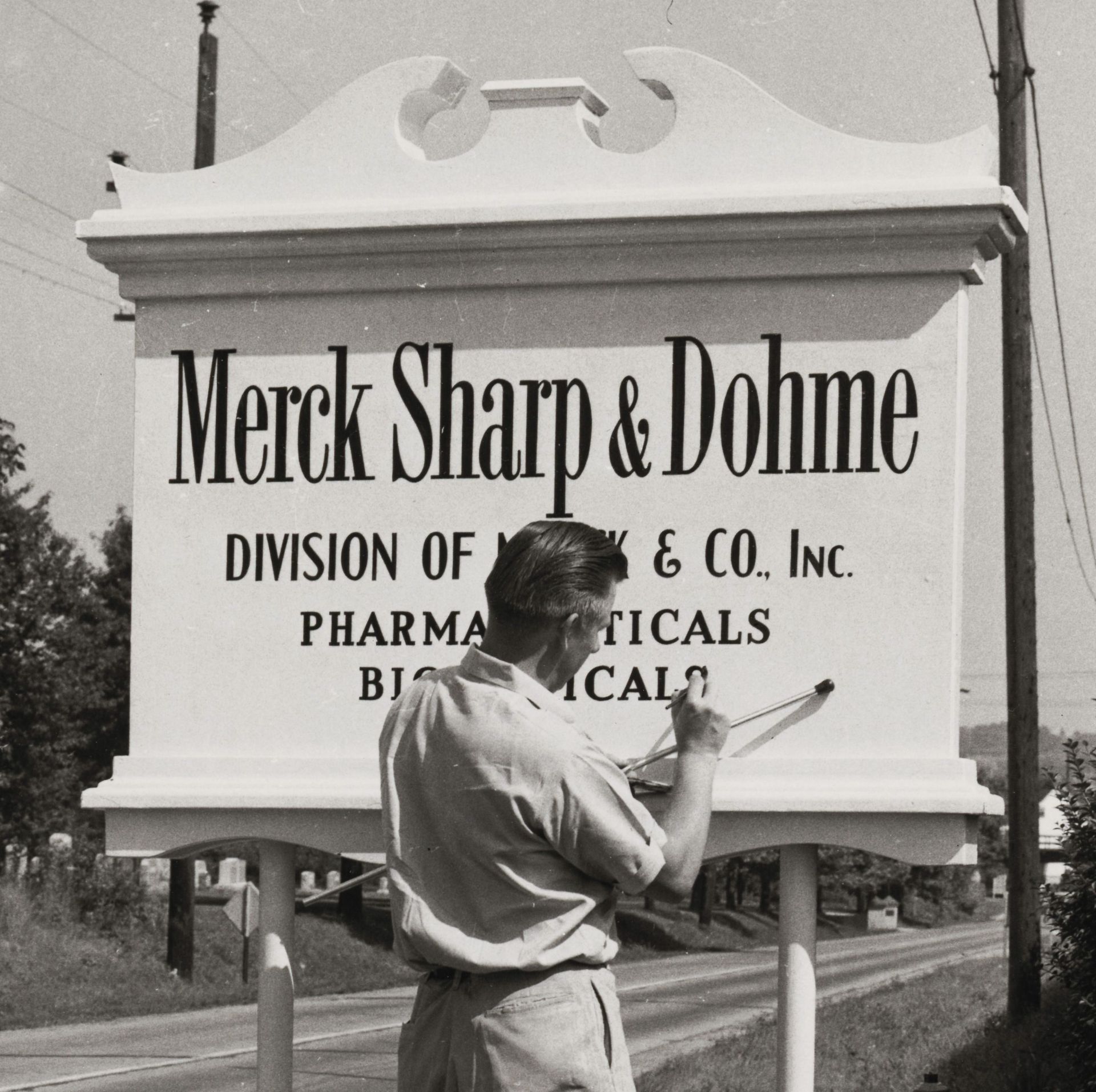 Mann beschreibt das Firmenschild von Merck & Co., Inc., Rahway, NJ, USA