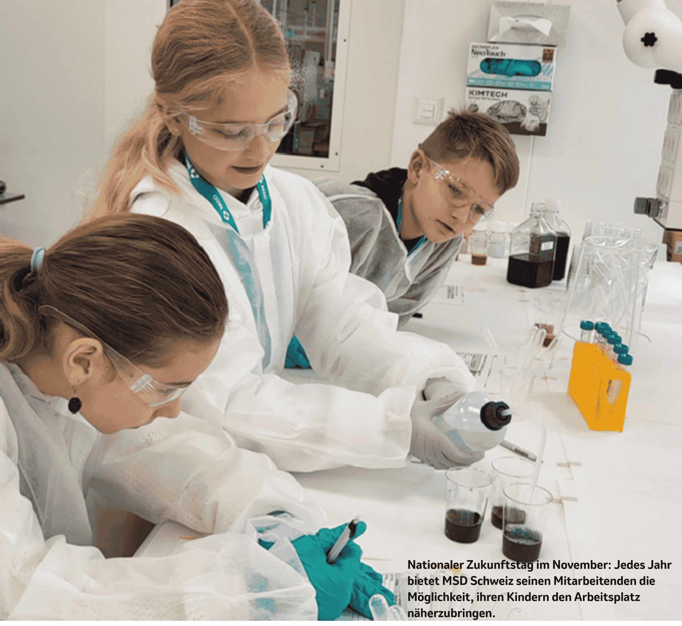 Foto: Kinder in Laborkitteln und Schutzbrillen führen während des National Future Day bei MSD Schweiz Experimente durch.