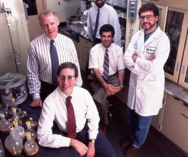 A team of researchers stands smiling in the laboratory