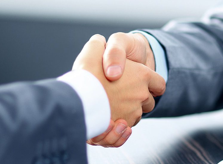 Two men shake hands