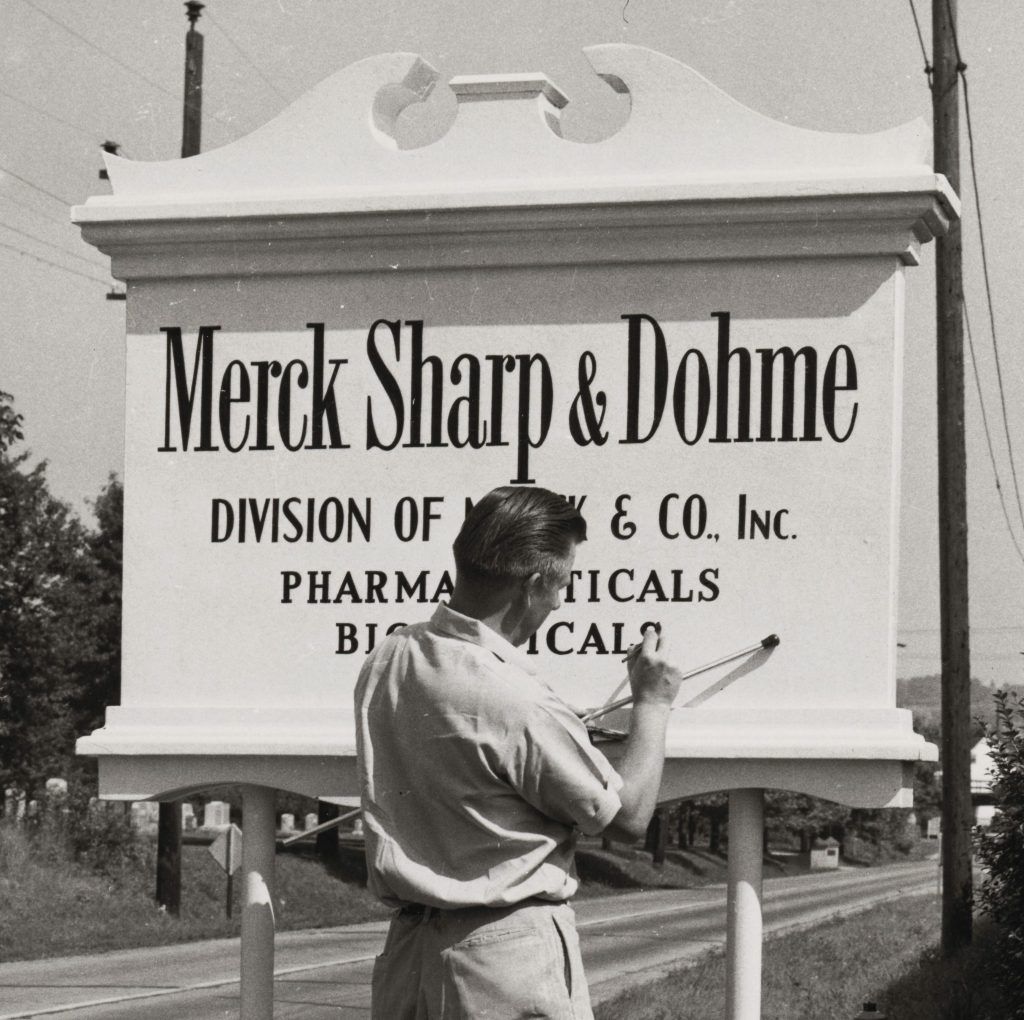 Un homme décrit l'enseigne de Merck & Co., Inc., Rahway, NJ, USA